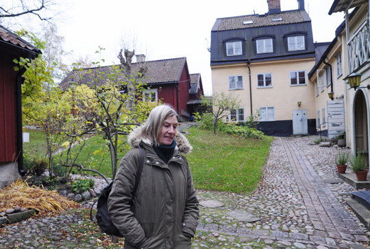 Lena Kallenerg bland äldre hus på en typisk södergård.